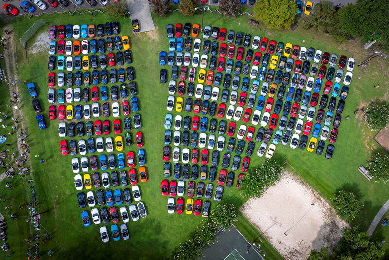 Aerial view of several hundred Miatas parked in rows across a field at Miatas at the Gap.